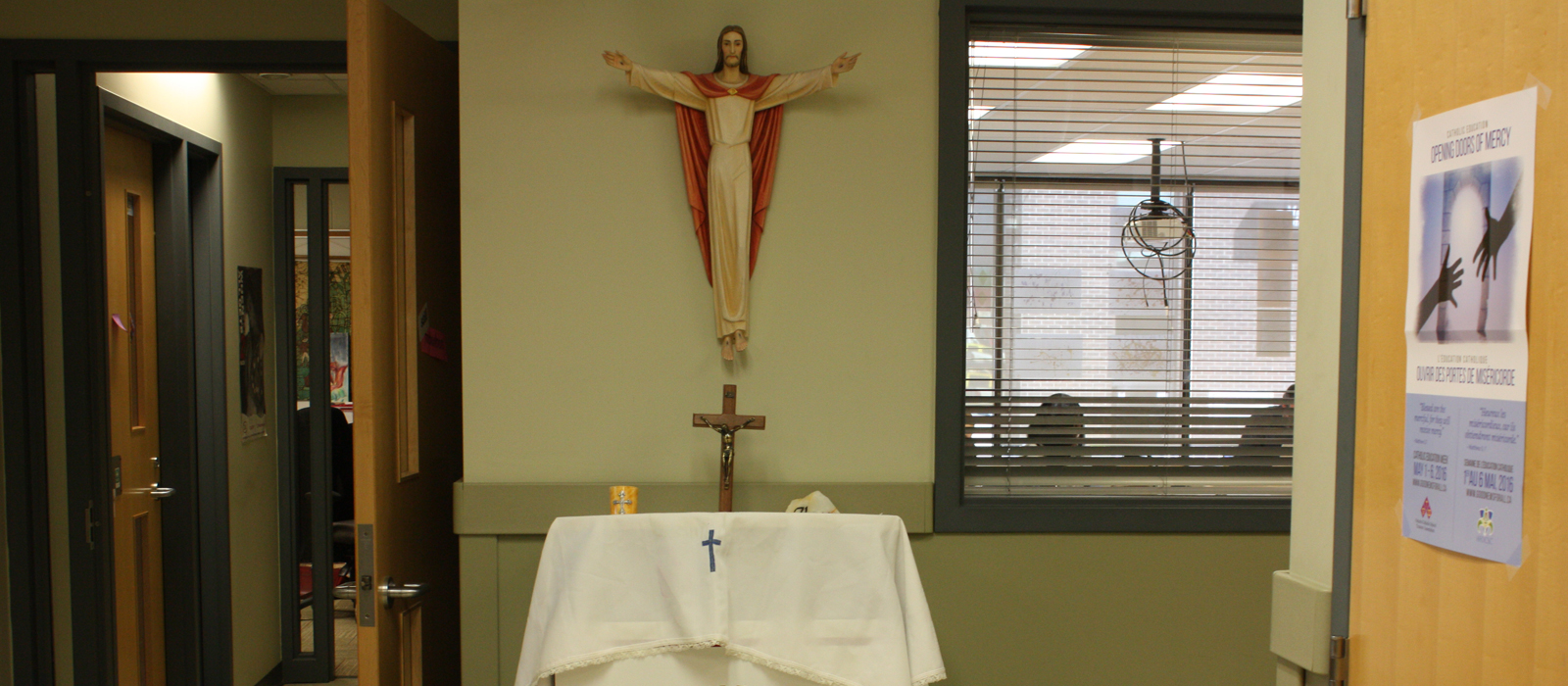 Statue of Jesus with arms open above an alter