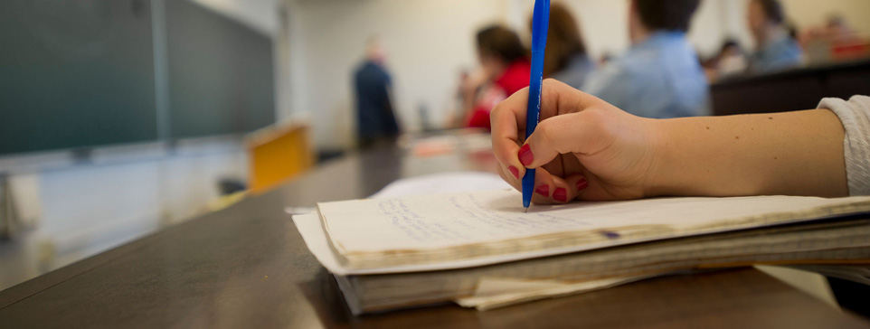 Hand holding pen writing