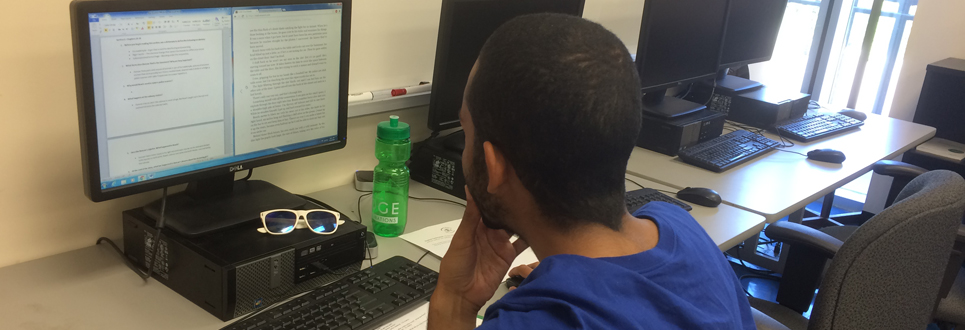 Male student reading computer screen